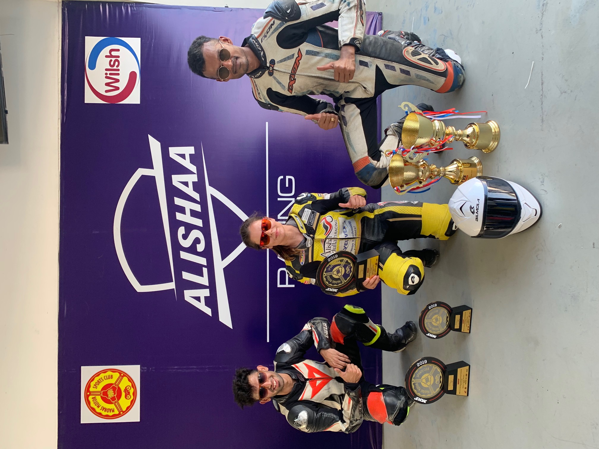 Alisha with team and trophies