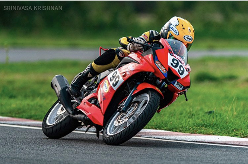 Alisha leaning into a corner on red bike